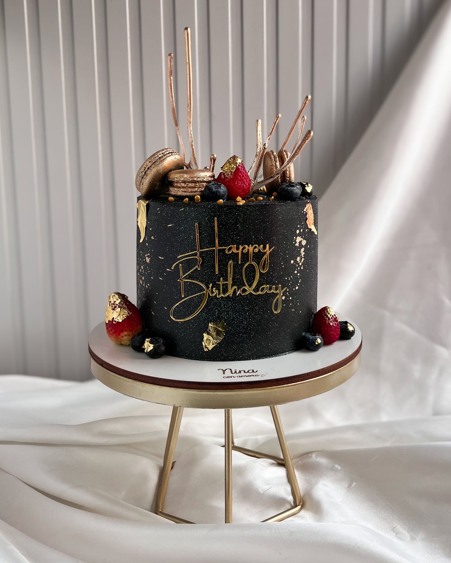 CAKE NEGRA CON MACARONS DORADOS Y FRUTAS